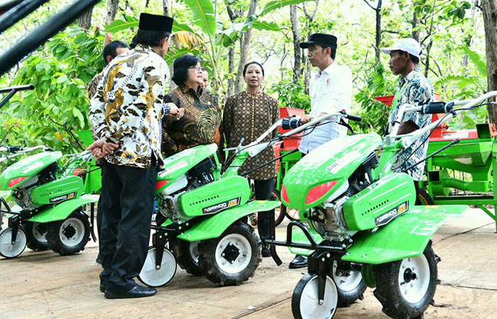 Presiden Joko Widodo menyerahkan bantuan untuk pemanfaatan hutan sosial kepada warga