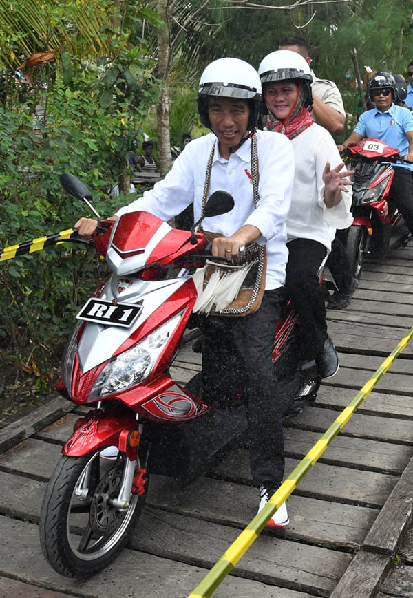 Presiden Jokowi dan Ibu Iriana tampak santai berkendara sepeda motor listrik menuju lokasi kunjungan