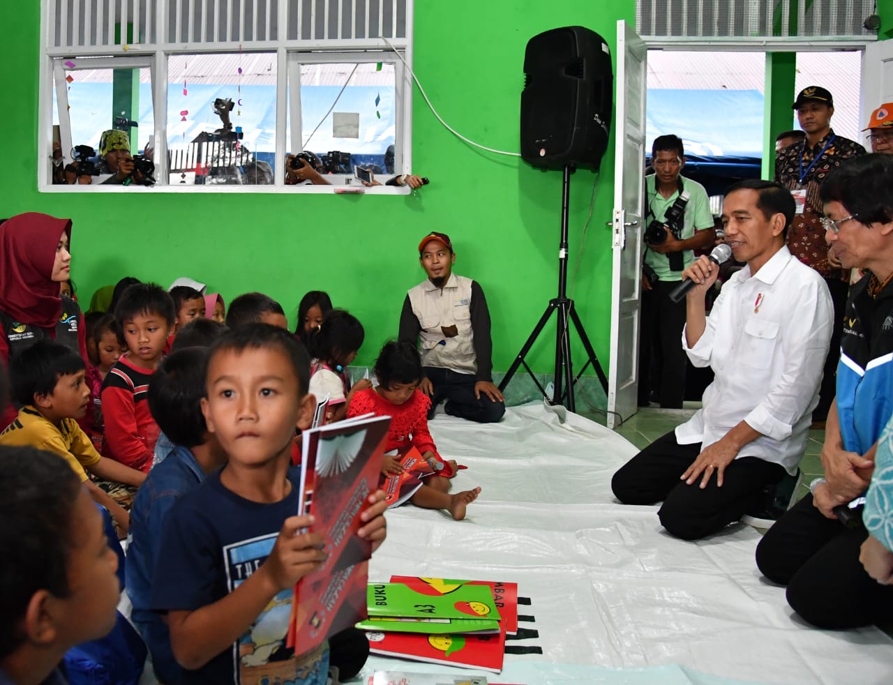 Presiden bertemu dengan anak-anak korban gempa. Presiden menyempatkan berdialog dan membagikan buku tulis untuk mereka.