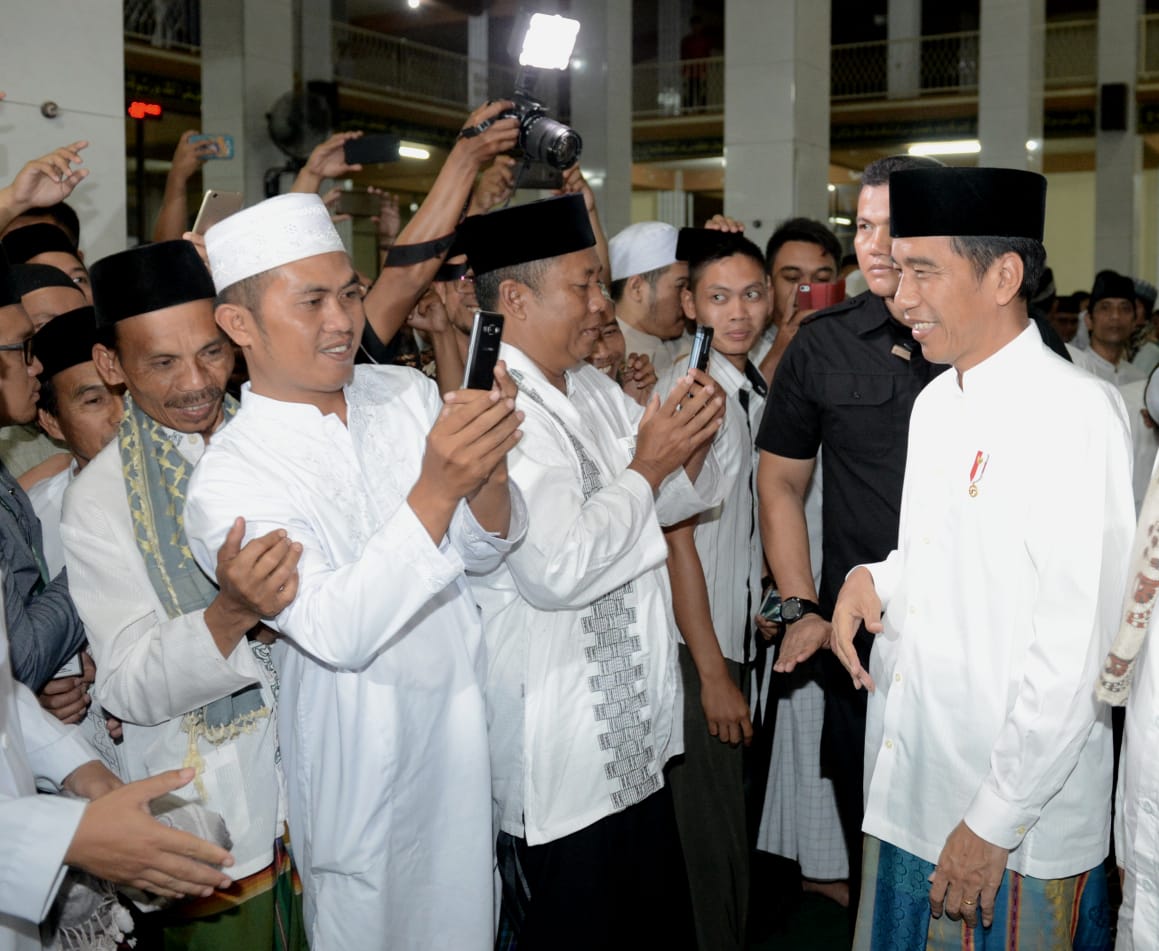 Umat Muslim di Masjid Agung Al-Istiqomah, Cilimus, Kabupaten Kuningan, Jawa Barat mengabadikan orang nomor satu di Indonesia yang ikut salat tarawih bersama. 