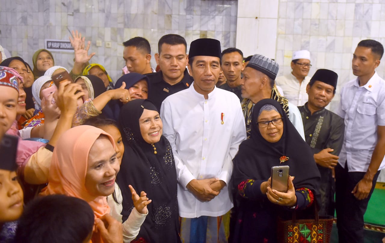 Masyarakat sekitar tampak antusias menyambut kehadiran Presiden Jokowi. 