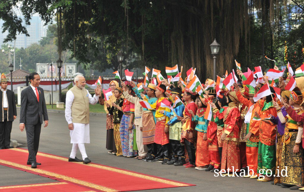 Presiden Jokowi pun tampak berbincang akrab bersama PM Narendra Modi, seraya berjalan menyusuri barisan anak-anak berpakaian adat yang menyambut PM India.