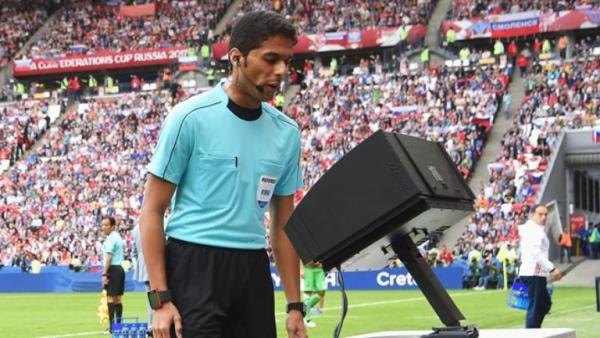 Wasit melihat rekaman VAR. Foto: FIFA