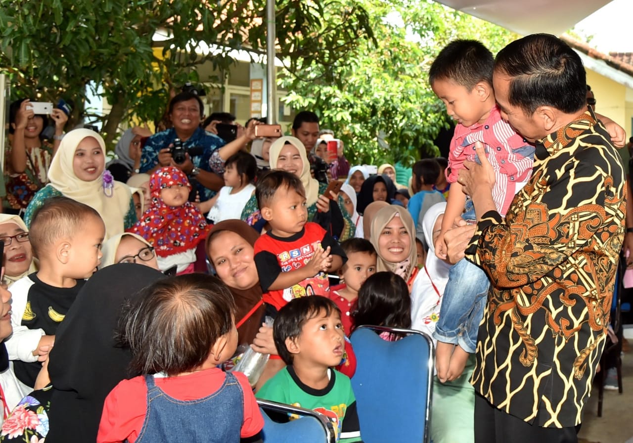 Presiden Joko Widodo menggendong seorang anak saat blusukan ke Desa Tangkil, Kecamatan Caringin, Kabupaten Bogor, Rabu (4/7) 2018. Ia mendorong untuk menaruh perhatian setinggi-tingginya unuk para generasi penerus bangsa ini.  