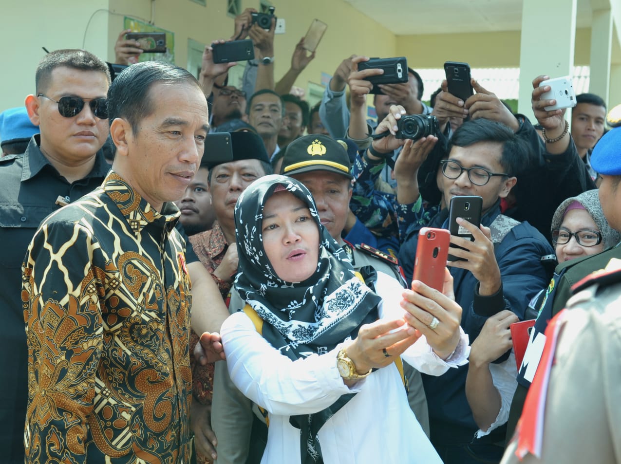 Presiden Joko Widodo menerima ajakan foto bersama warga Desa Tangkil, Kecamatan Caringin, Kabupaten Bogor,