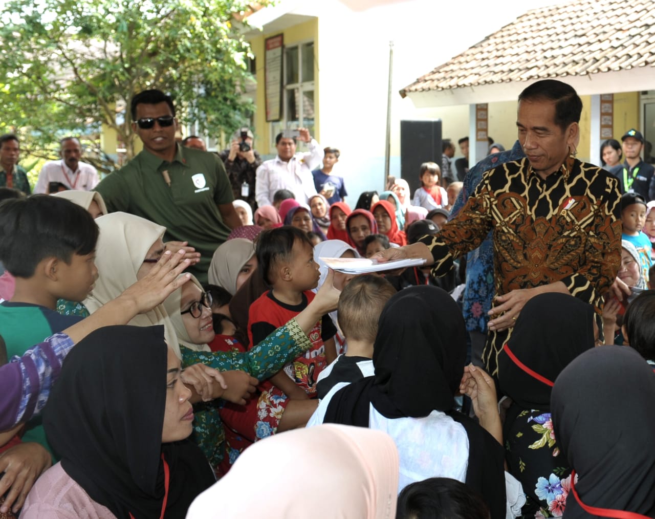 Presiden Jokowi dan Jim Yong Kim membagikan sejumlah buku tulis untuk anak-anak dan mencicipi penganan penambah gizi anak.