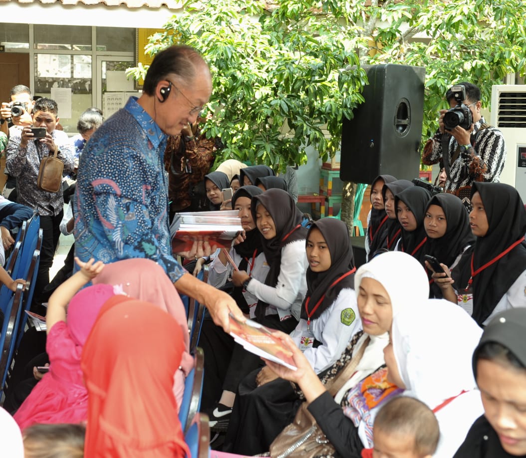 Presiden Jokowi dan Jim Yong Kim membagikan sejumlah buku tulis untuk anak-anak dan mencicipi penganan penambah gizi anak.